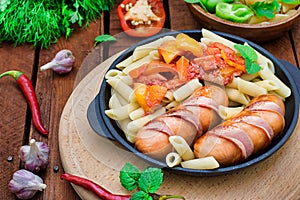 Pasta with sausages and lecho. Wooden rustic background. Selective focus. Top view
