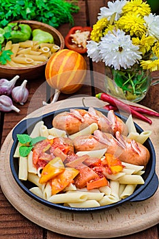 Pasta with sausages and lecho. Wooden rustic background. Selective focus. Top view