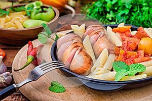 Pasta with sausages and lecho. Wooden rustic background. Selective focus. Top view