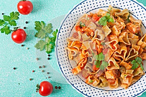 Pasta in the shape of hearts with chicken and tomatoes in tomato sauce.