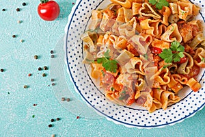 Pasta in the shape of hearts with chicken and tomatoes in tomato sauce.