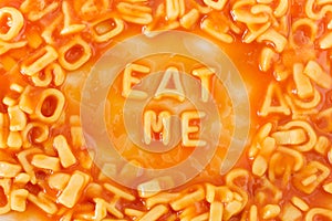 Pasta shaped letters spelling EAT ME in tomato sauce