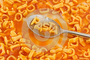 Pasta shaped letters spelling the word PASTA in tomato sauce on