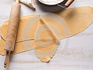 Pasta sheets and rolling pin for making ravioli.