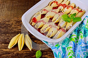 pasta shells stuffed with minced beef meat with herbs and tomato sauce