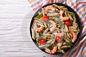 Pasta with shrimp, tomato and pesto sauce. horizontal top view