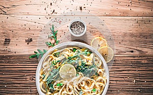 Pasta with a sour cream lemon and herbs on wooden table