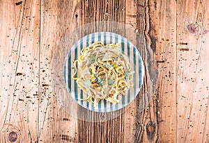 Pasta with a sour cream lemon and herbs on wooden table