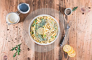 Pasta with a sour cream lemon and herbs on wooden table