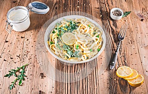 Pasta with a sour cream lemon and herbs on wooden table