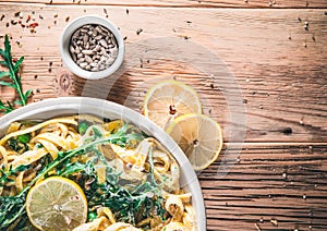 Pasta with a sour cream lemon and herbs on wooden table