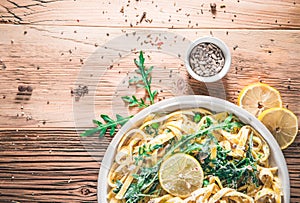 Pasta with a sour cream lemon and herbs on wooden table