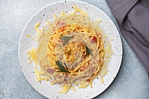 Pasta spaghetti with bacon egg cheese on a plate with spices. Traditional Italian dish Carbonara. Grey concrete table. Copy space