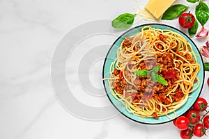 Pasta spaghetti bolognese on a blue plate on white marble table. healthy food. view from above