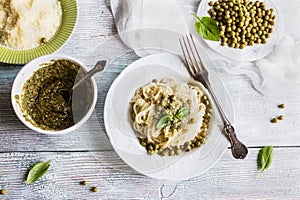 Pasta spaghetti green beans, sauce pesto, parmesan, fresh basil. Vintage plates, wooden table, top view