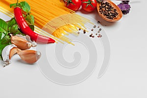 Pasta Spaghetti with ingredients for cooking pasta on a white background, top view.