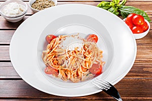 Pasta Spaghetti with olive oil, cheese, herbs and tomatoes on woPasta Spaghetti with olive oil, cheese, herbs and tomatoes on wood