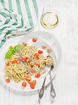 Pasta spaghetti with pesto sauce, cherry-tomatoes, white wine
