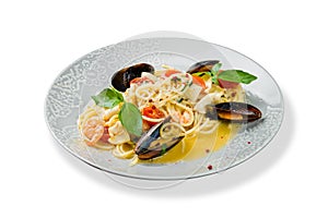 Pasta spaghetti with seafood, shrimps, mussels, tomatoes and basil isolated on white