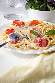 Pasta spaghetti with tomato sauce and cheese parmesan served on dark plate on table background