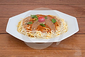 Pasta spaghetti with tomato sauce on a white plate. copy space. Wood background