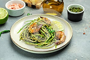 Pasta spaghetti zucchini basil pesto sauce and grilled shrimp, Vegetarian vegetable pasta, Food recipe background. Close up