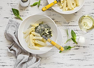 Pasta with spinach cream sauce and a glass of white wine