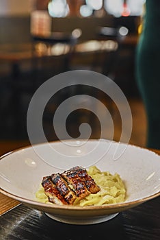 Pasta tagliatelle with bolgnese sauce and meat steak cut in pieces served on a plate over black background.