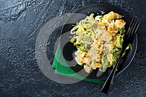 Pasta Tagliatelle in creamy sauce with baked cauliflower in a plate on a dark background. Selective focus.Top view