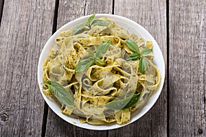 Pasta tagliatelle with green sauce pesto . Italian food background