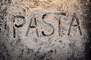Pasta text on flour top view