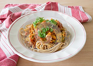 Pasta with tomato sauce, white plate wooden table