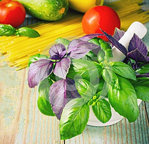 Pasta, tomatoes, and basil on wooden background