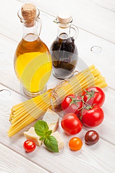 Pasta, tomatoes, basil on wooden table