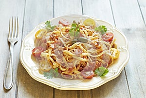 Pasta with tomatoes, ham, capers and cheese