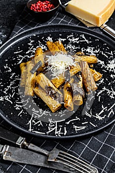 Pasta tortiglioni with black truffle and Boletus edulis, white mushroom. Black background. Top view