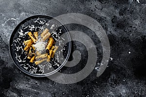 Pasta tortiglioni with black truffle and Boletus edulis, white mushroom. Black background. Top view. Space for text