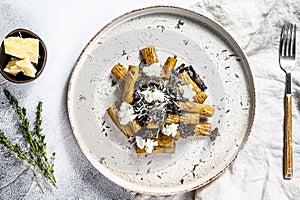 Pasta tortiglioni with black truffle and Boletus edulis, white mushroom. Gray background. Top view