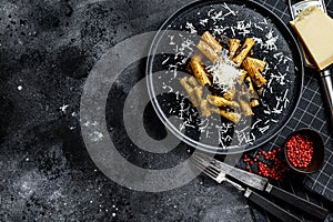 Pasta tortiglioni with black truffle, white mushroom, Cream Sauce and parmesan cheese. Black background. Top view. Space for text