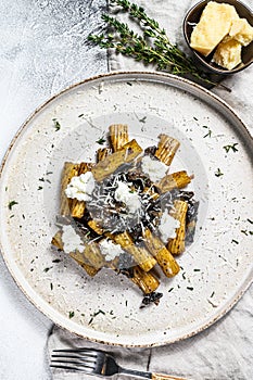 Pasta tortiglioni with black truffle, white mushroom, Cream Sauce and ricotta cheese. Gray background. Top view