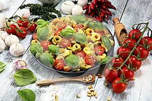 Pasta. tricolor tortellini pasta salad with tomatoes and onions on wood table background