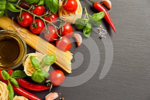 Pasta, vegetables, herbs and spices for Italian food on black background