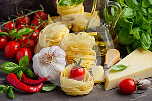 Pasta, vegetables, herbs and spices for Italian food on the wooden background