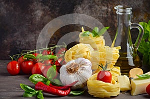 Pasta, vegetables, herbs and spices for Italian food on the wooden background