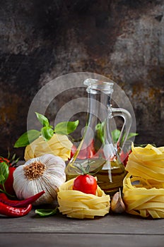 Pasta, vegetables, herbs and spices for Italian food on the wooden background