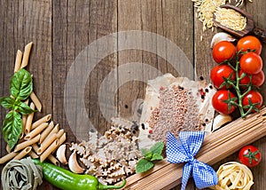 Pasta, vegetables and herbs on wood