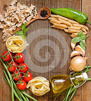 Pasta, vegetables and herbs on wood