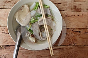 Paste of rice flour with spoon and chopsticks in the bowl isolated on wooden background closeup.