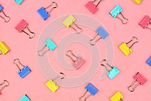 Pasted colored paper clip pattern on a pink background