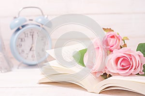 Pastel artificial rose and open book with vintage tone